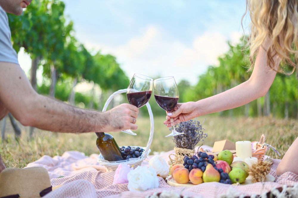 Pareja brindando con dos copas de vino en un viñedo