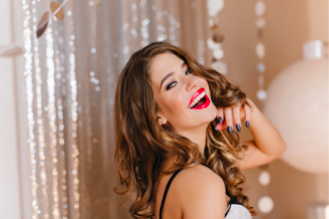 Mujer joven guapa sonriendo y maquillada con labial rojo intenso
